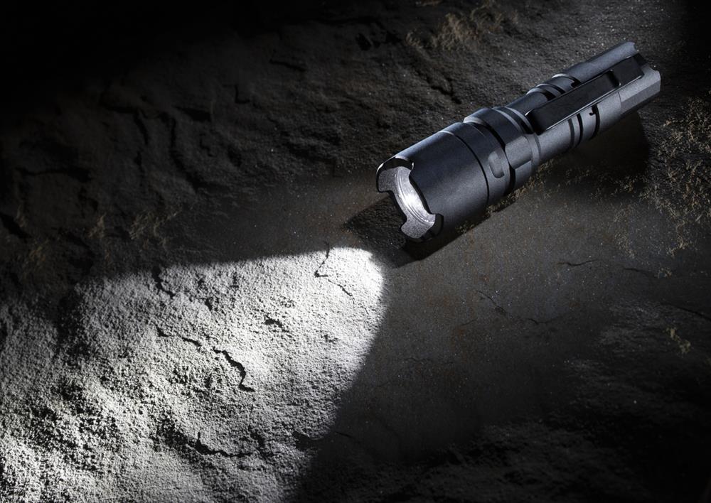 A tactical flashlight on the ground