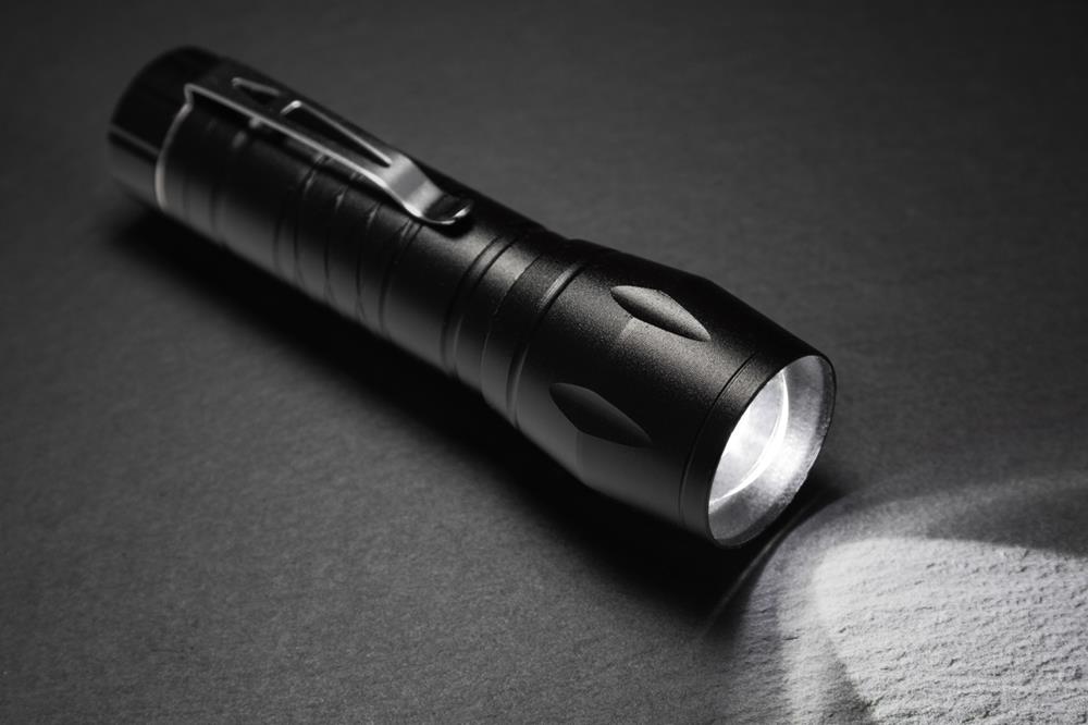 A black flashlight on a surface