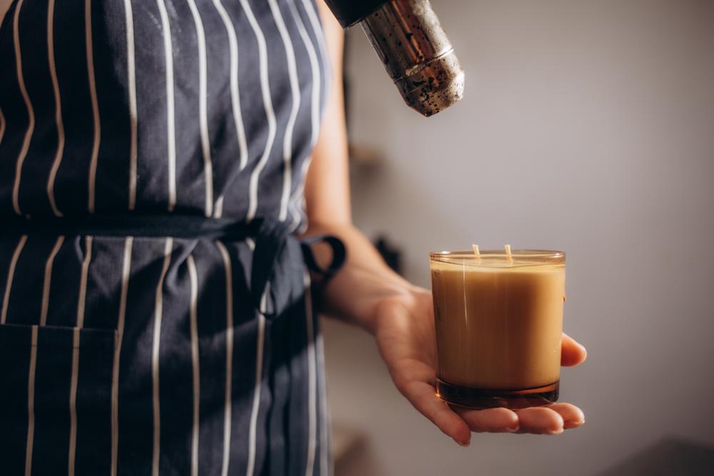 Woman using a hair dryer on a candle