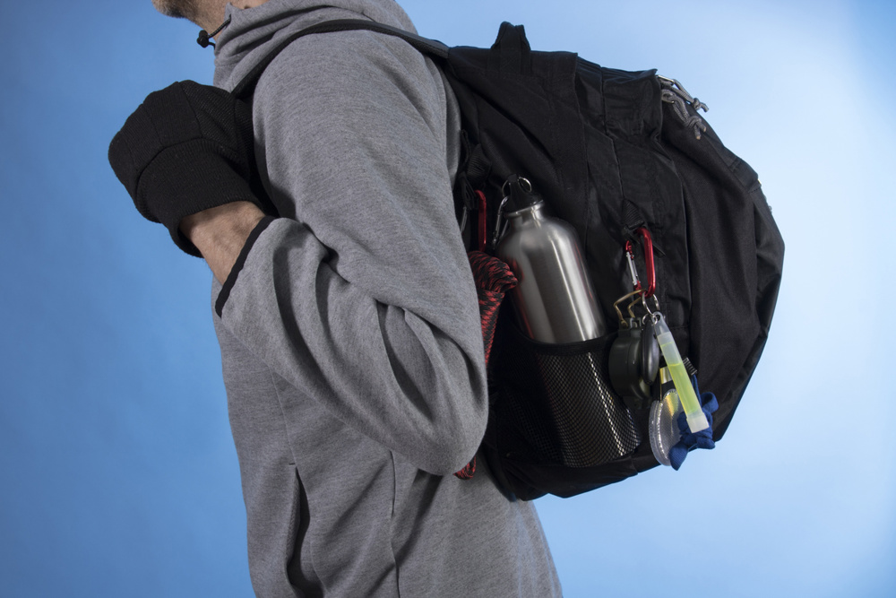 Man with bugout bag on blue background