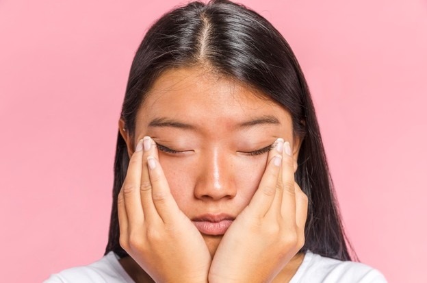 Woman rubs her eyes close-up