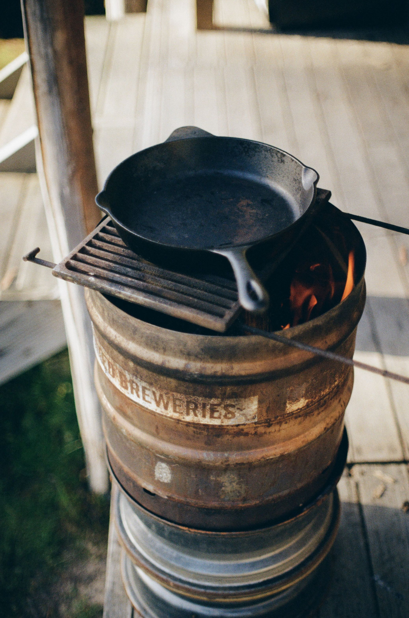 Closeup of a frying pan on an iron barrel in a garden