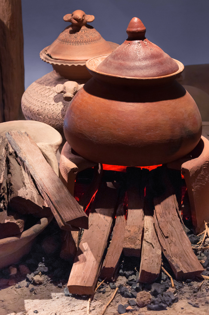 Traditional pottery clay pot on brick campfire with fire