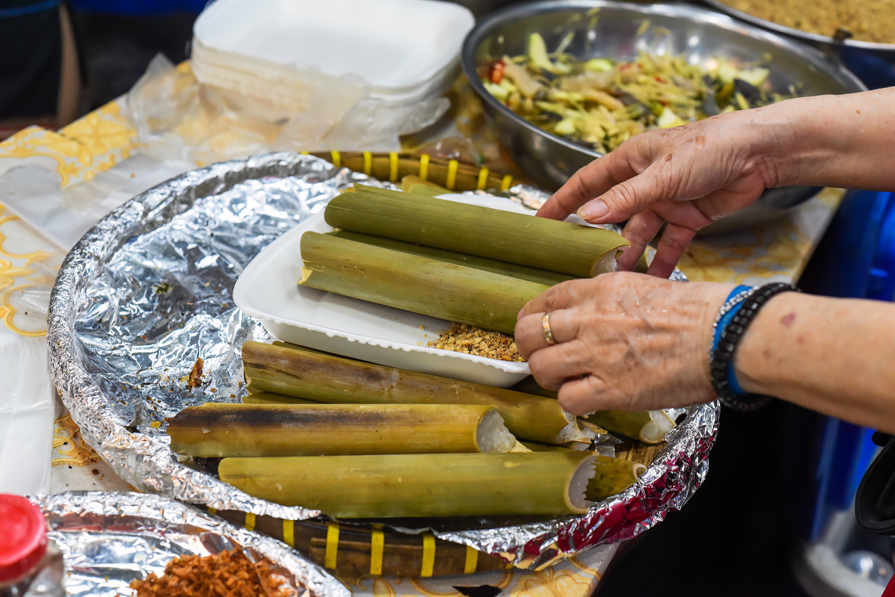 Vietnamese woman cooking sticky rice in bamboo in vietnamese night market