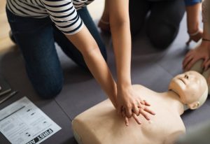 A person performing CPR on a dummy
