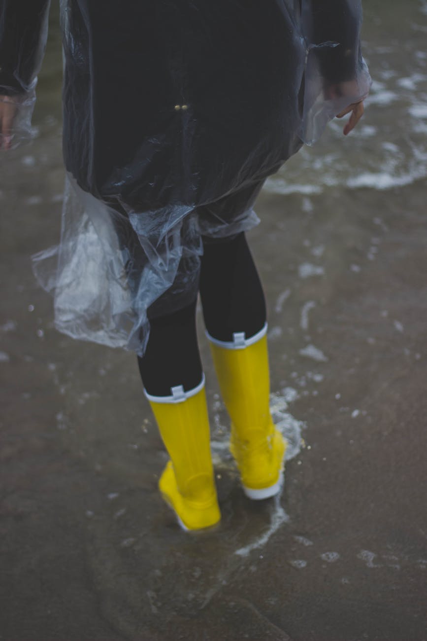 A person wearing a raincoat and standing in water