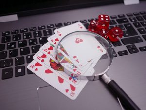 playing cards and dice on top of a laptop