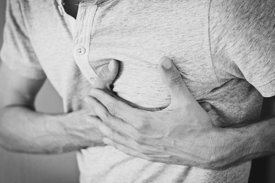A man holding his chest due to heartache